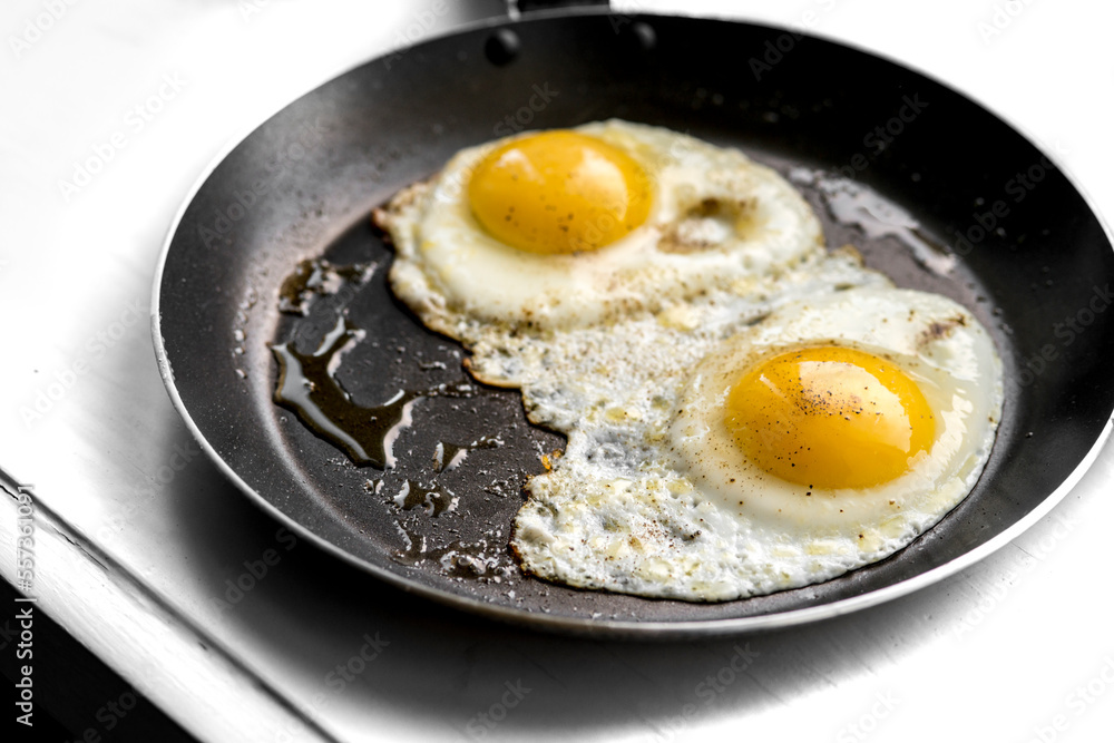 close-up shot of fried eggs on black pan close-up shot of fried eggs on black pan