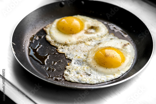 close-up shot of fried eggs on black pan