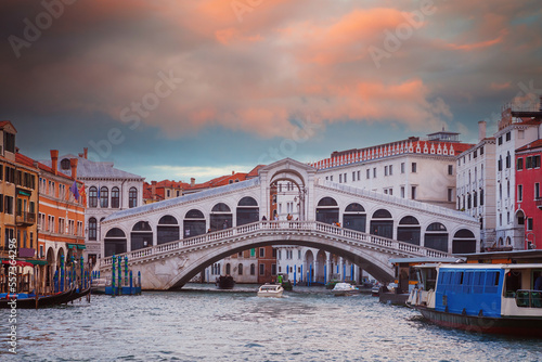 Famous Rialto bridge  early in the morning  with traditional gondolas  passenger transport boat (vaporettos)  on the Grand Canal in Venice  Italy © jarcosa