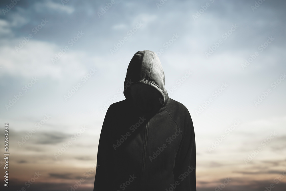 surreal man with hood and obscured face wanders aimlessly - obrazy, fototapety, plakaty 