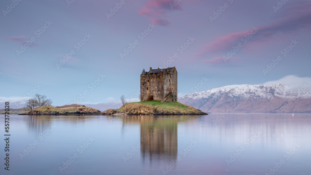 Castle Stalker near Appin, Oban and Glencoe in the Scottish Highlands. Landscape photography with a pink sunrise and snow capped mountains	