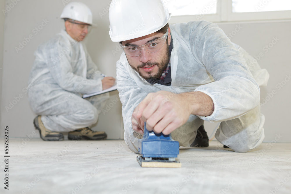 man sanding floor wearing protective equipment man sanding floor wearing protective equipment