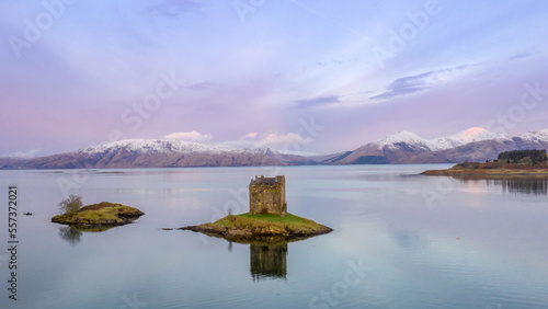 Castle Stalker near Appin, Oban and Glencoe in the Scottish Highlands. Landscape photography with a pink sunrise and snow capped mountains 