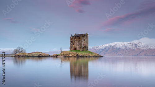 Castle Stalker near Appin, Oban and Glencoe in the Scottish Highlands. Landscape photography with a pink sunrise and snow capped mountains	