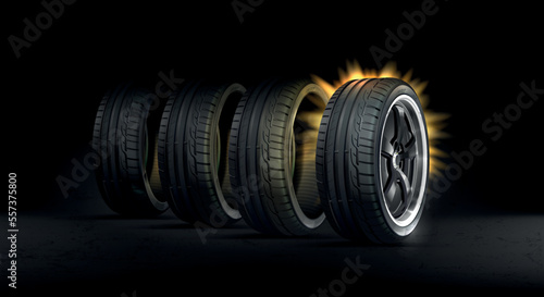 Set of car tires. Black background. 4 car tires on asphalt. Wheel with disc luminous halo.