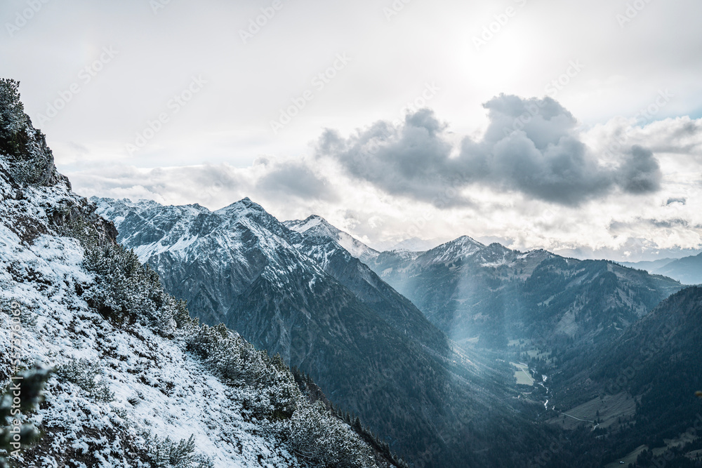 Scenic mountain view with snowcapped mountains under a cloudy dramatic sky