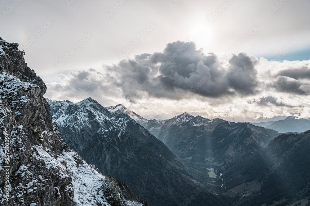 Obraz premium Scenic mountain view with snowcapped mountains under a cloudy dramatic sky