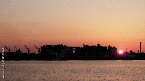 巨大工場群のシルエットの奥に沈む太陽 © 雑猫