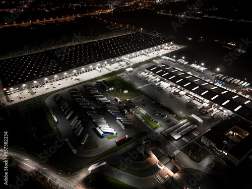 Night aerial view of a warehouse of goods for online stores. Logistic center in the industrial area of the city from above.