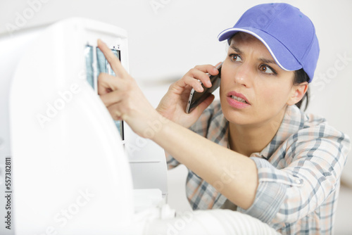 female worker repairing air conditioner photo