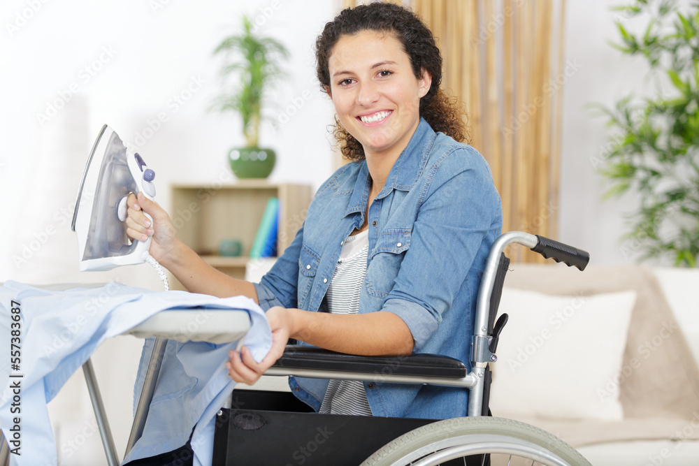 Obraz premium happy disable woman ironing at home