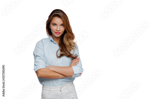Half length shot of pleasant looking female model wears shirt and white jeans, keeps arms folded looks confidently at camera, has long hair, poses against purple background, blank space for promo