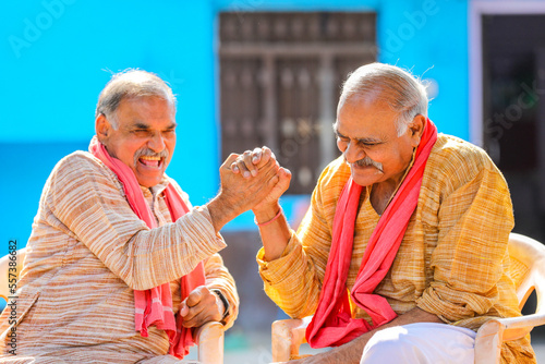 Old and senior indian farmers standing and giving happy expression photo