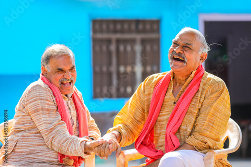 Two indian old farmer discussing at out of home. photo