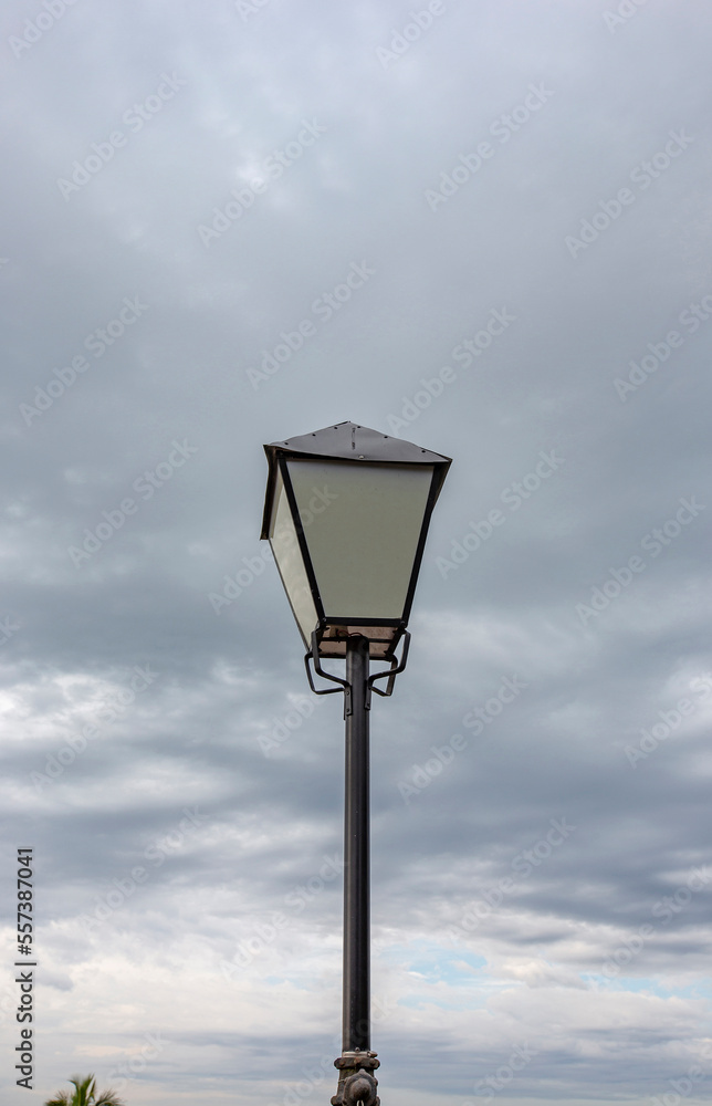 Old light pole isolated under dark clouds sky