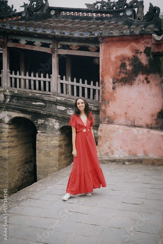 tourist girl in red dress on Cau Temple bridge, hoi an ancient town in vietnam
