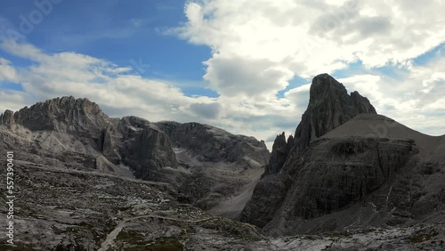 An endless view on a high desolated mountain peaks in Italian Dolomites, South Tyrol (Alto Adige), Italy, Europe. Idyllic hiking trail to Oberbachernspitz. Raw unspoiled landscape. Cloud covered sky