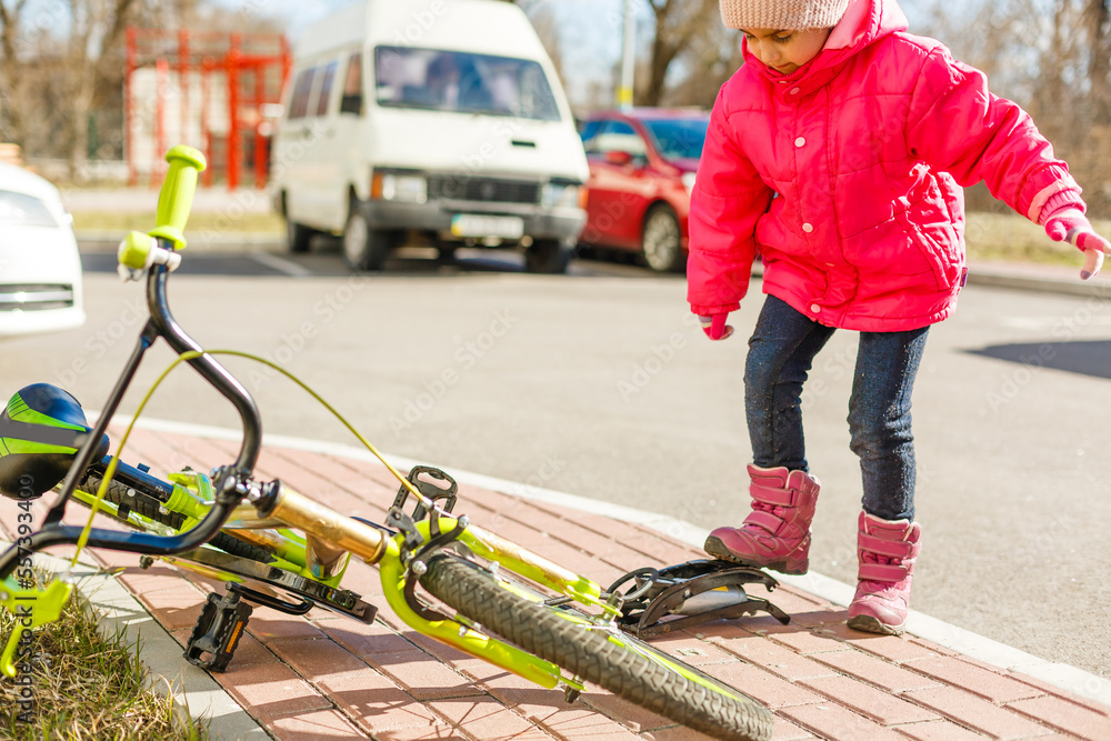 Obraz premium a little girl pumps up a bicycle tire.