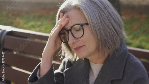 Wallpaper Mural Elegant mature woman resting on bench feeling terrible headache, massaging temples and forehead, suffering dizziness and migraine attacks, menopause symptoms Torontodigital.ca