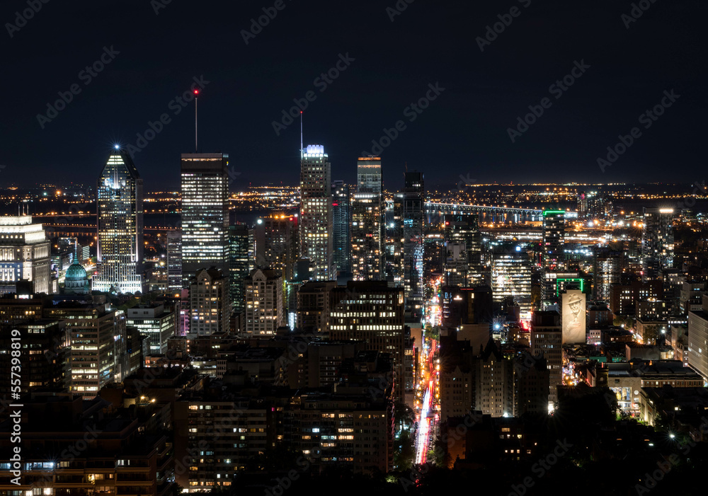 Montreal at night.Montreal panorama viewed from the Mount Royal.Night view of Montreal skyline with tall skyscrapers and busy street