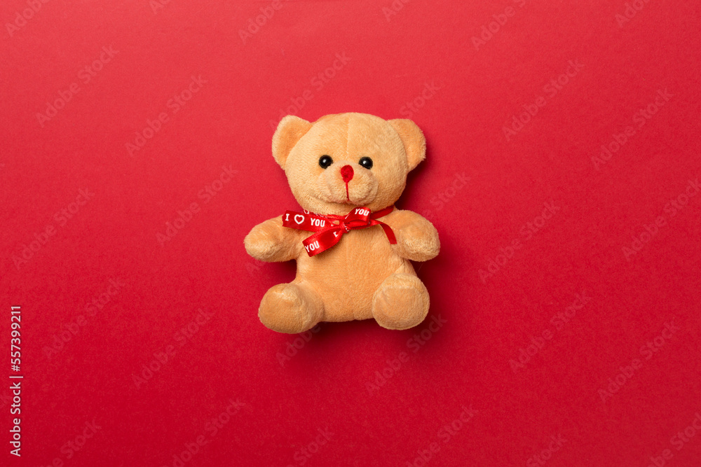 Cute teddy bear on color background, top view