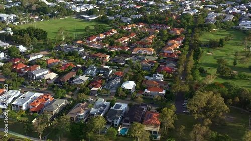 Aerial birds eye view overlooking at residential houses in Bulimba neighborhood, tilt pan shot overlooking at riverside townscape across Morningside and Murarrie suburbs, Queensland. photo