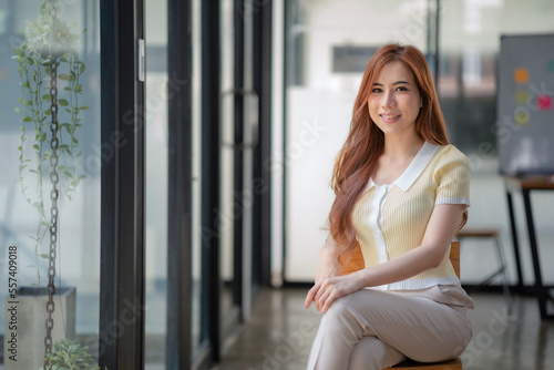 Portrait Asian woman sitting on a chair and looking at a camera. Free Download Portrait Asian woman sitting on a chair and looking at a camera. - GFXLoad