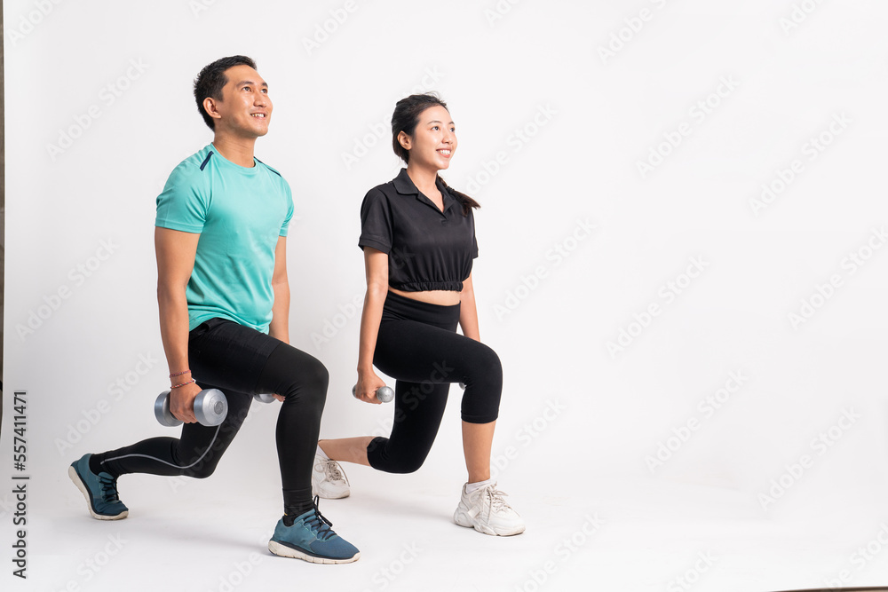 Obraz premium side view of man and woman squatting with dumbbells in both hands on white background