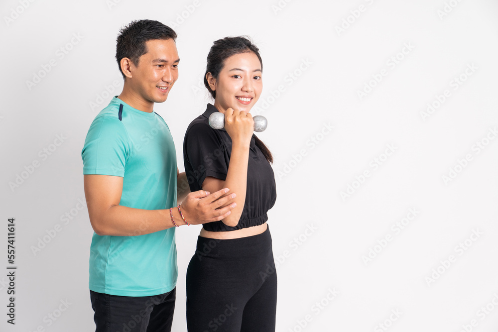 sporty woman lifting dumbbells with a male trainer on isolated background sporty woman lifting dumbbells with a male trainer on isolated background