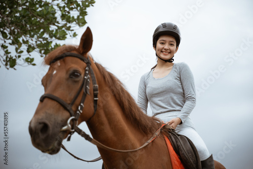 beautiful woman equestrian athlete practicing horse riding on outdoor background © Odua Images