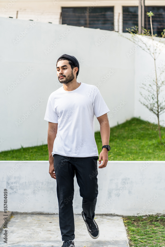 A young bearded handsome man doing a pose while wearing his white blank shirt A young bearded handsome man doing a pose while wearing his white blank shirt