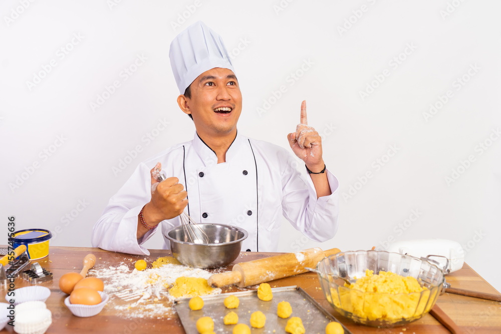 male chef gesturing for ideas using whisk in mixing bowl on table on isolated background male chef gesturing for ideas using whisk in mixing bowl on table on isolated background