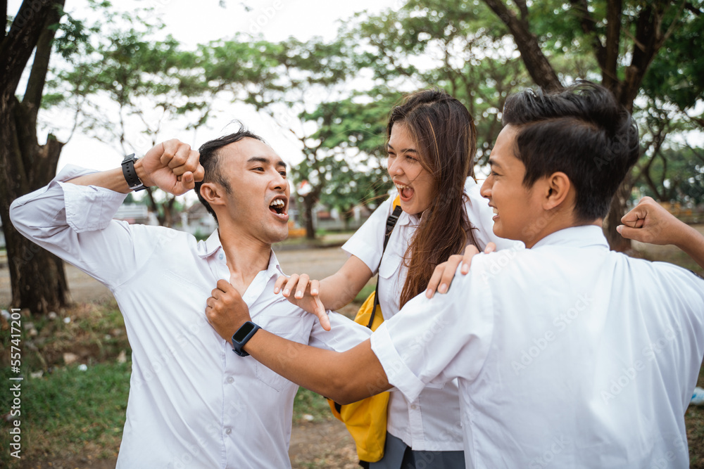 Two male high school students in uniform fight between a girl at school Two male high school students in uniform fight between a girl at school