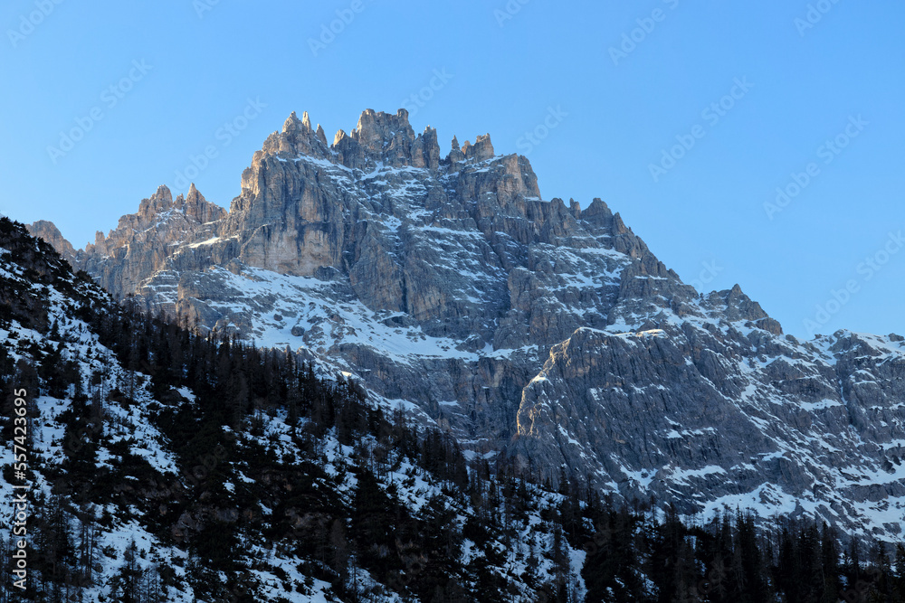 Last sunlight on the snow covered mountain peaks of the Sesto Dolomites in Winter. Alps, South Tyrol, Alto Adige, Italy, Europe