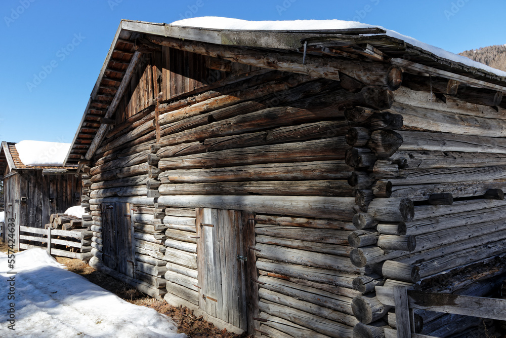 Old wooden huts in a mountain forest in late winter, Alps, Europe Old wooden huts in a mountain forest in late winter, Alps, Europe