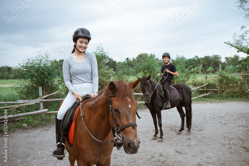 two equestrian athletes ride horses and start training in outdoor background © Odua Images