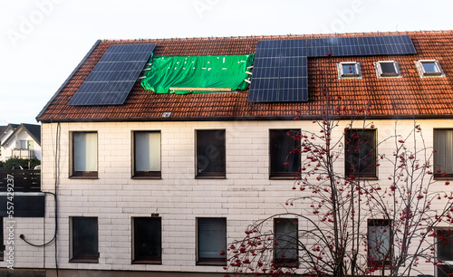 leaking roof covered with green tarpaulin, bungle in construction. photo