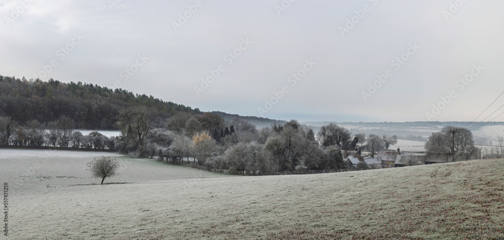 Beautiful Winter landscape of farm in fog in English countryside at dawn with hoarfrost covering trees and buildings Beautiful Winter landscape of farm in fog in English countryside at dawn with hoarfrost covering trees and buildings