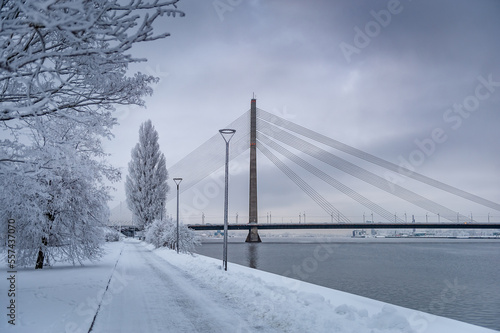 Walking path overlooking the cable-stayed bridge which crosses the Daugava river in Riga, Latvia. Winter cityscapes.
