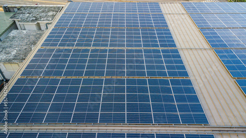 Aerial view of a solar panel photovoltaic with reflection on building roof top.
