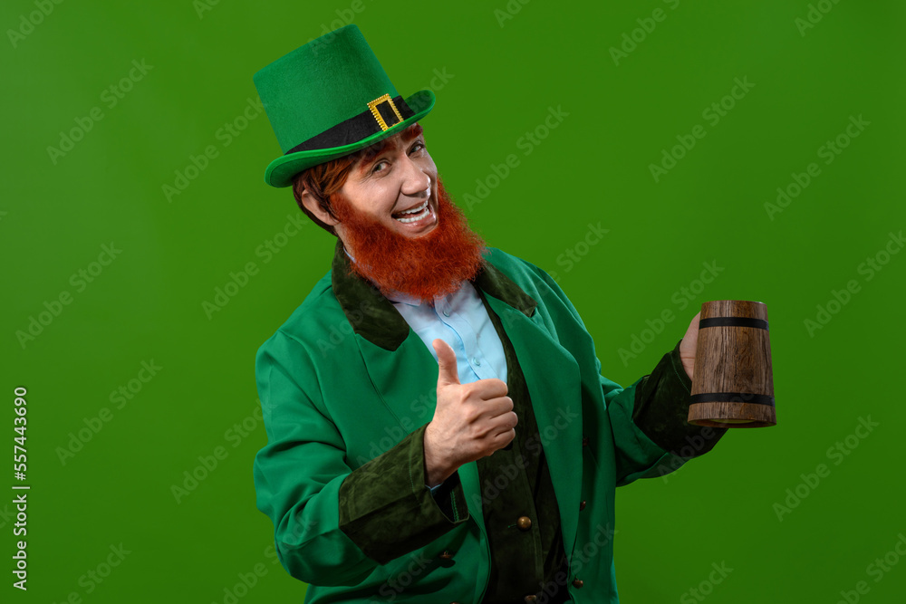 Leprechaun elf on St. Patrick's Day. Cheerful character Irish leprechaun for advertising with a red natural beard in a green suit and green hat for advertising. Cosplay at the festival on March 17th Leprechaun elf on St. Patrick's Day. Cheerful character Irish leprechaun for advertising with a red natural beard in a green suit and green hat for advertising. Cosplay at the festival on March 17th