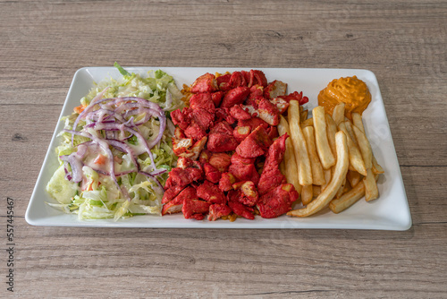 Paris, France - 12 07 2022: Middle East dishe culinary Still Life. Tandoori chicken platter with french fries and salad photo