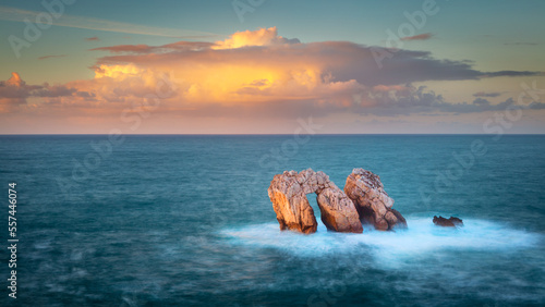 The seastacks Urro Mayor and Urro Menor in the sea off the coast at the village of Liencres, Spain at sunset photo