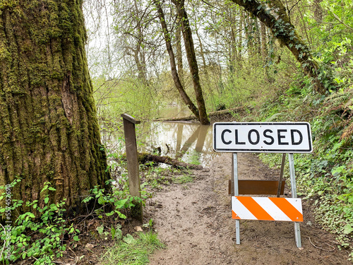 A closed sign on a trail due to flooding water