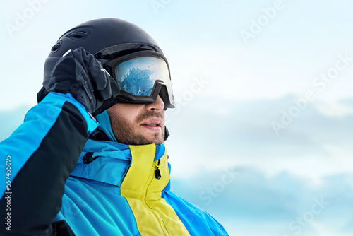 Close Up Of The Ski Goggles Of A Man With The Reflection Of Snowed Mountains. Man In The Background Blue Sky.  Winter Sports. © verona_studio