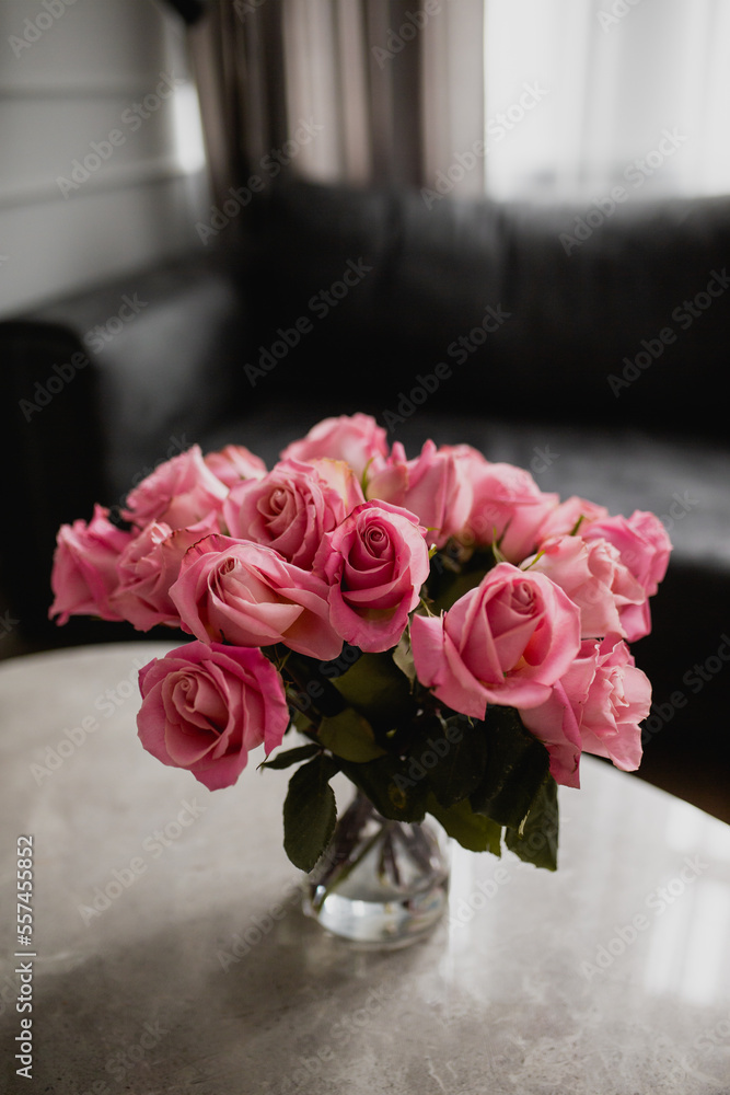 Obraz premium Pink roses on grey granite table with dark background