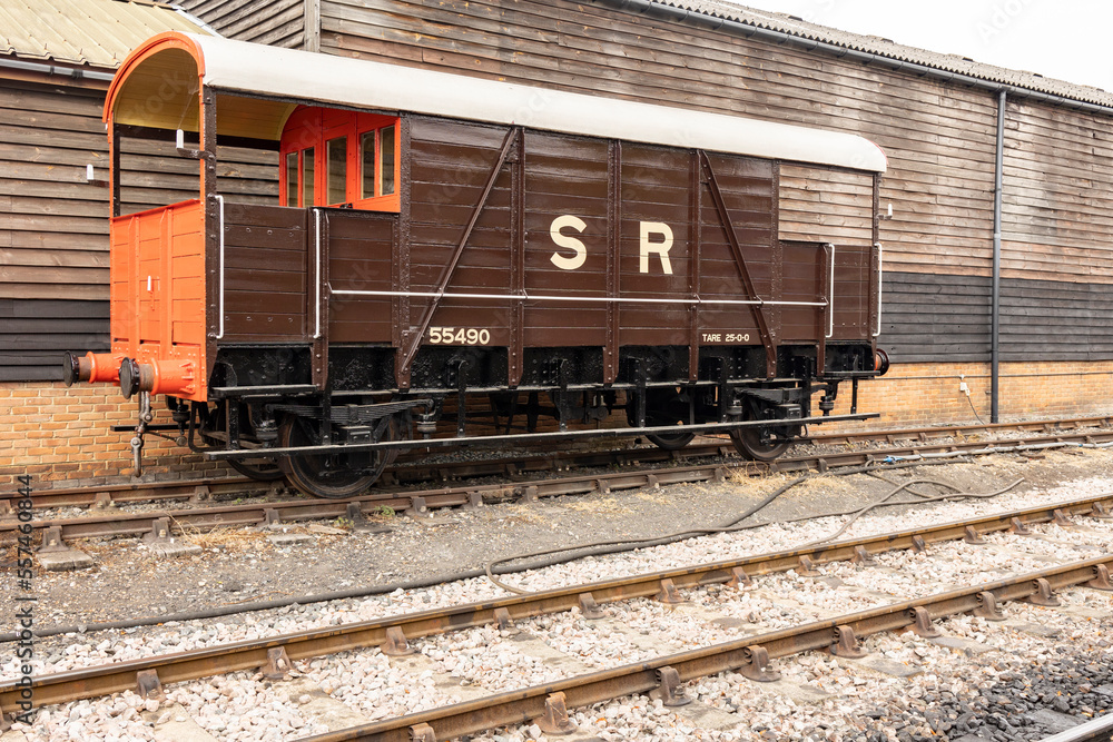 An old passenger railway car with peeling paint on the carriage of the railway. An old passenger railway car with peeling paint on the carriage of the railway.