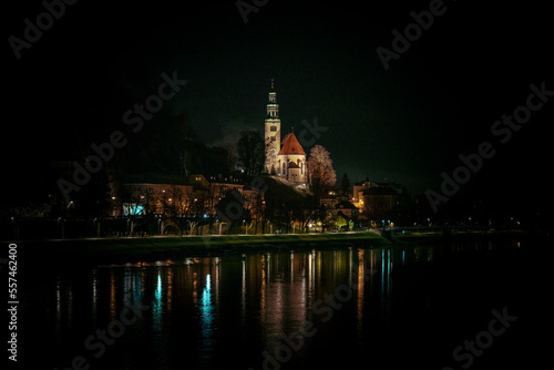 Müllner Church in Salzburg, Austria, at night with lights from the banks of the Salzach river