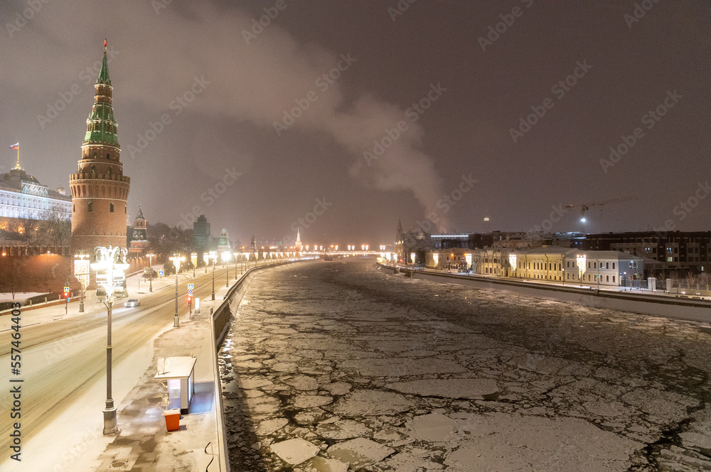 Moscow, Russia - December 27, 2022: Tower of the Moscow Kremlin. Cold and deserted Moscow street on a snowy winter evening near Red Square