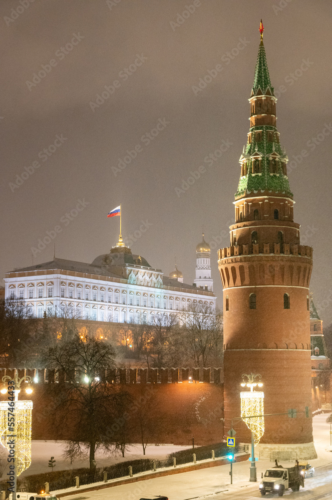 Moscow, Russia - December 27, 2022: Tower of the Moscow Kremlin. Cold and deserted Moscow street on a snowy winter evening near Red Square